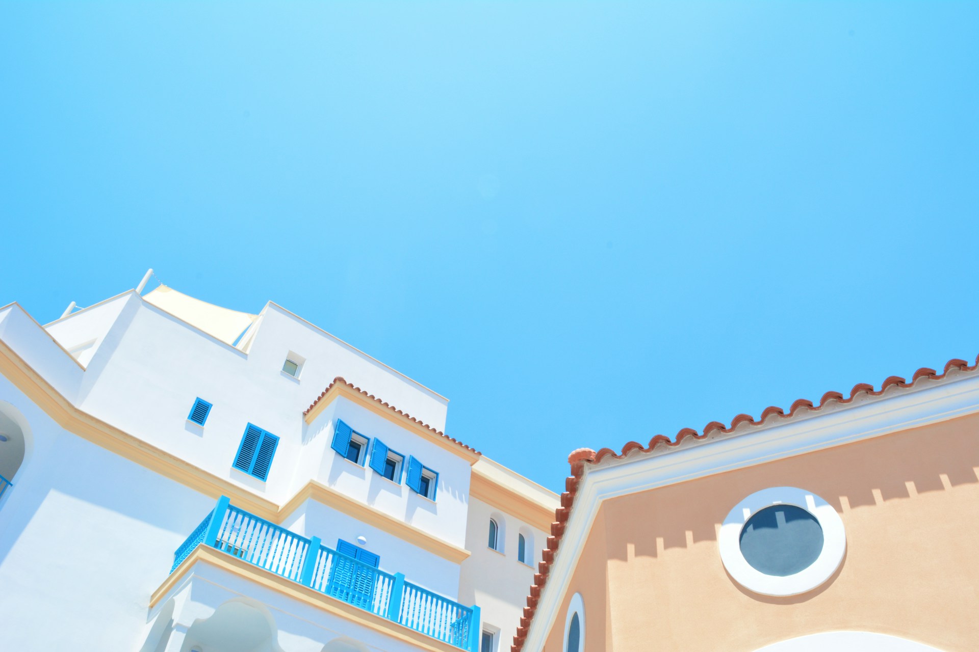 White buildings with blue shutters and terracotta roofs in Limassol, Cyprus. Illustrative photograph.